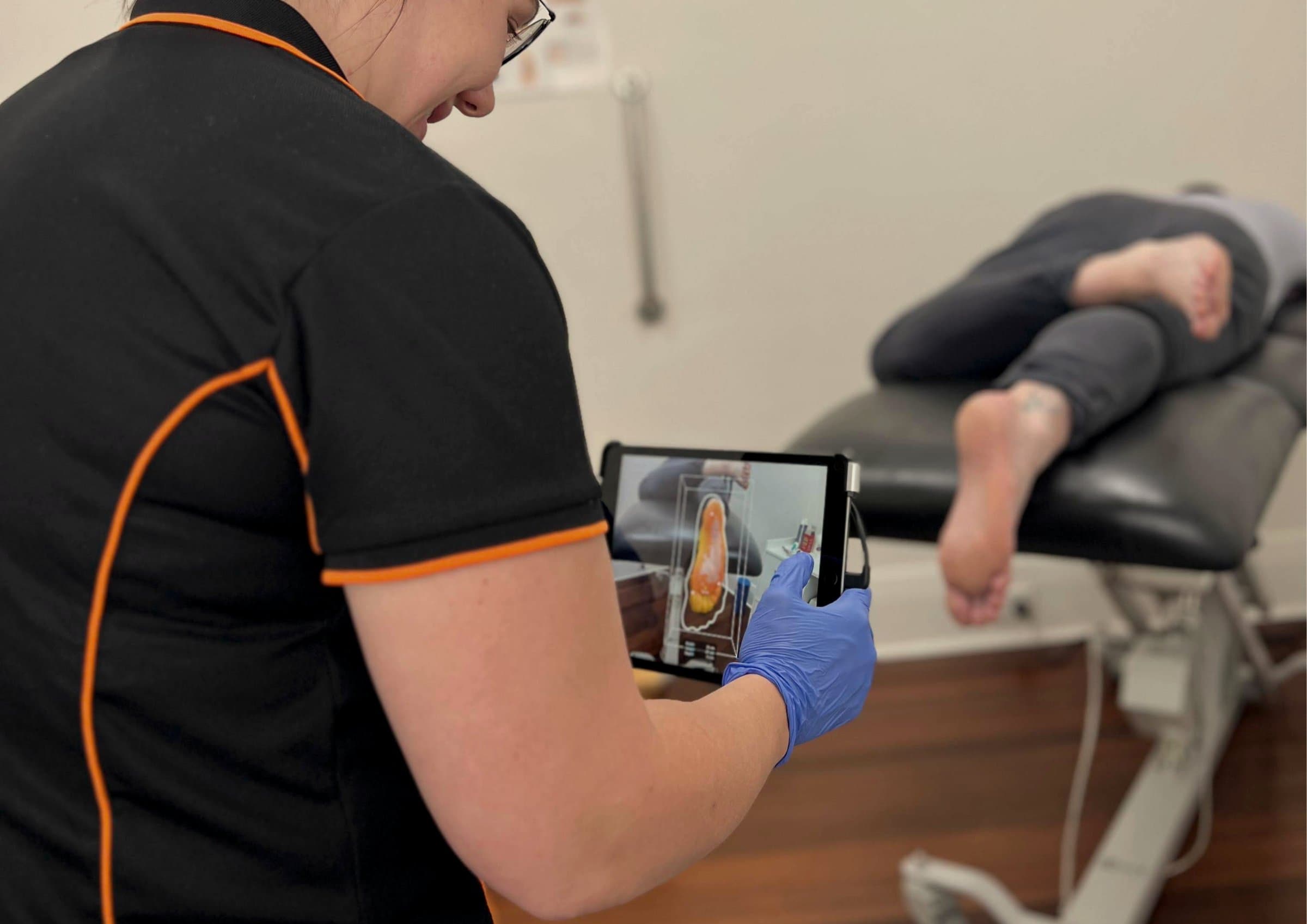 An Allied clinician reviewing a 3D foot scan chairside